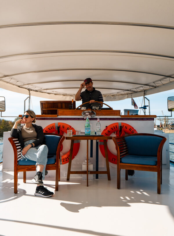 Guests relaxing on the covered deck area of La Vie en Rose, with blue upholstered chairs and tables.