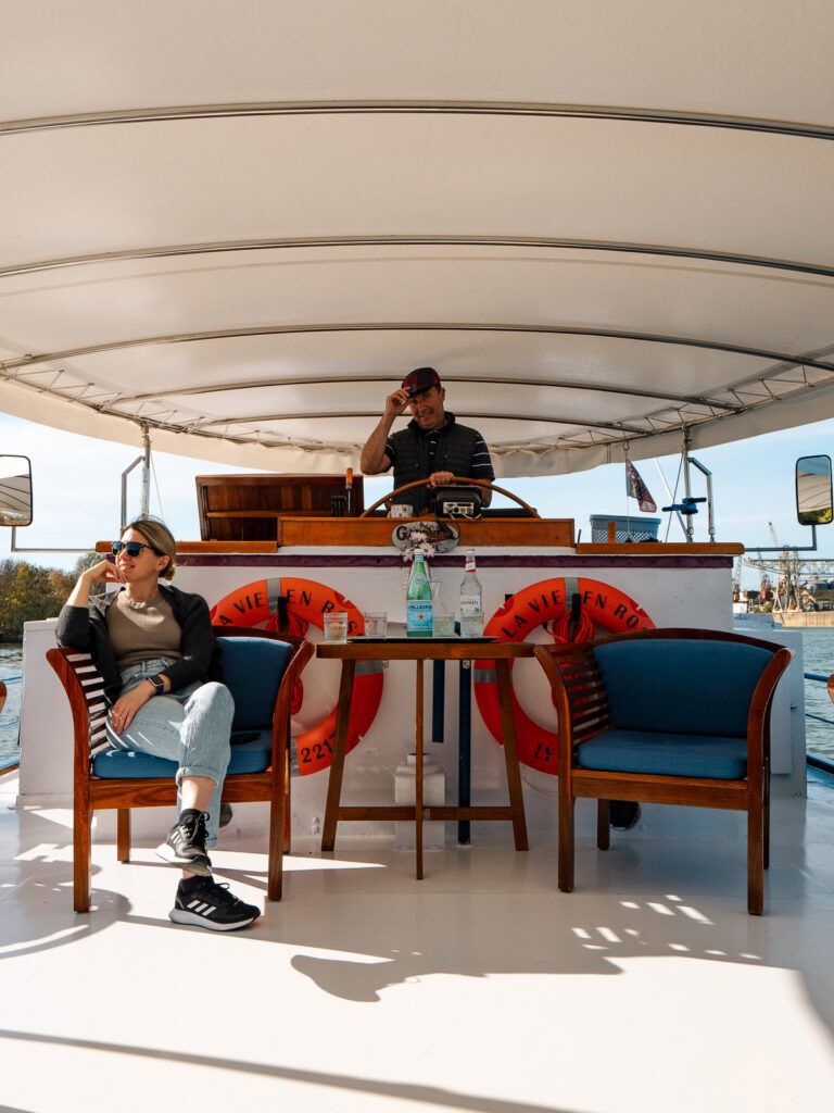 Guests relaxing on the covered deck area of La Vie en Rose, with blue upholstered chairs and tables.