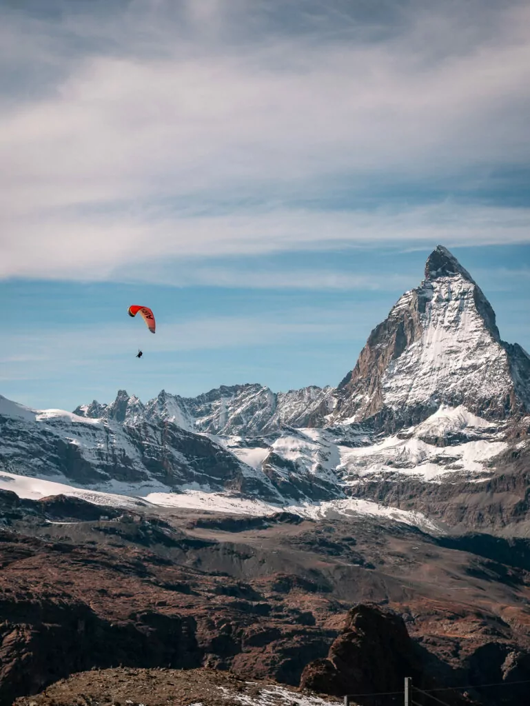 The Matterhorn peak with a paraglider soaring above Zermatt