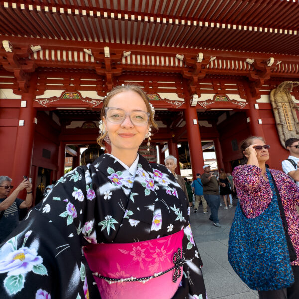 A woman in a beautiful floral yukata poses at Sensoji Temple in Tokyo, showcasing how solo female travel in Japan allows for memorable cultural experiences