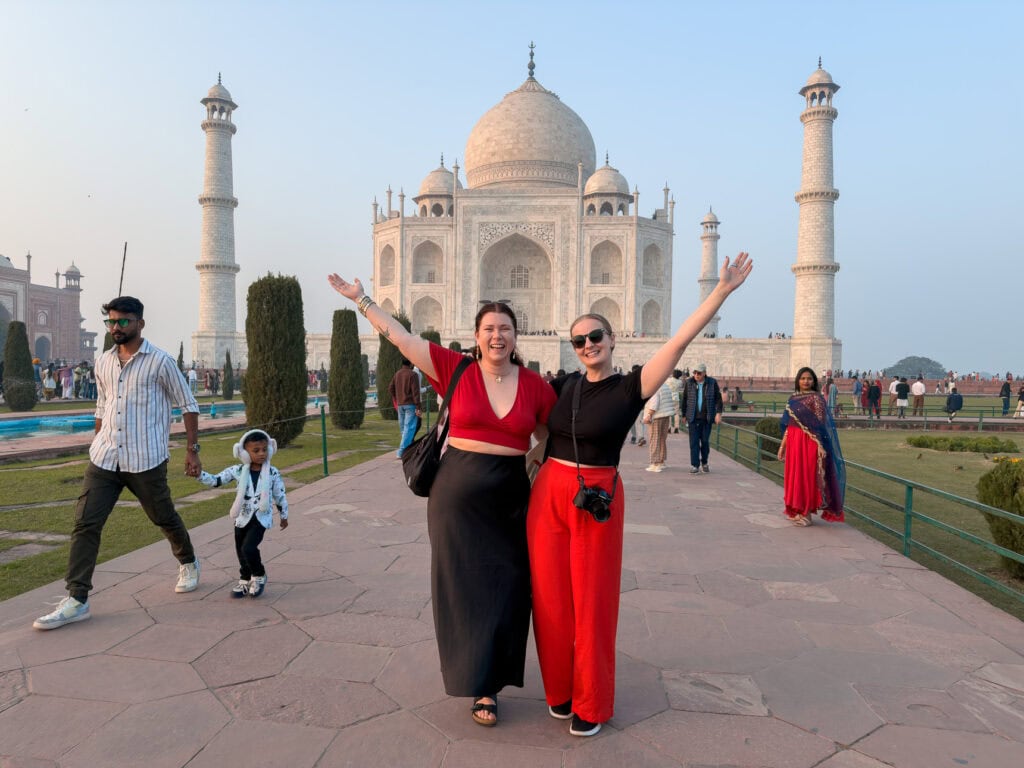 Travellers walk towards the Taj Mahal along the central pathway with the white marble monument framed ahead under a clear sky. This iconic highlight of the One Life Adventures India Classic tour is a must see on any India tour for solo travellers.