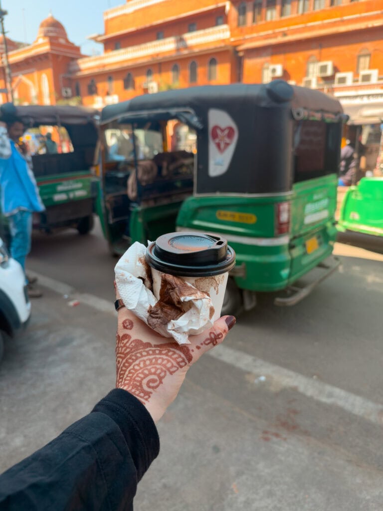 A cup of hot chocolate has spilled over napkins and a table during a bumpy tuk tuk ride