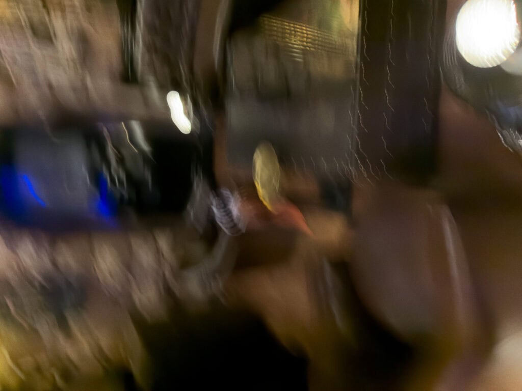 Blurred lights and movement capture a lively night out with people and drinks. The motion reflects the energy of nightlife during a group travel experience.