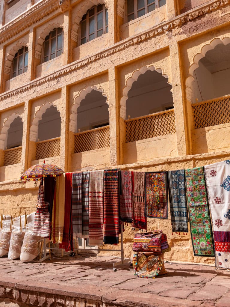 Detailed sandstone architecture inside Mehrangarh Fort with arches and shadowed corridors. The historic fort overlooks Jodhpur and is a highlight of an India tour.