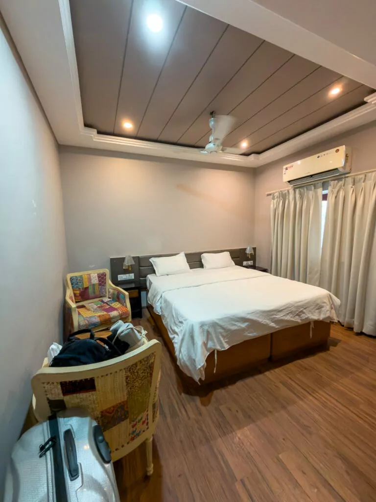 Bedroom at Kuchaman Haveli in Jodhpur with a double bed, warm coloured walls, and traditional decor