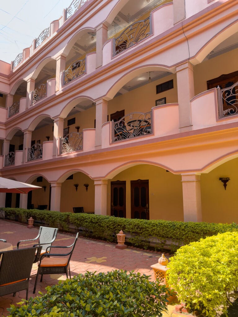 Courtyard of Master Paradise hotel in Pushkar with pink walls, balconies, and a central seating area
