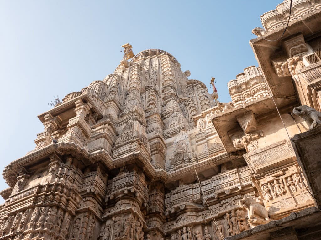 Detailed carvings on a Jain temple in Udaipur with intricate stonework and sculpted pillars. The architecture highlights religious craftsmanship in India