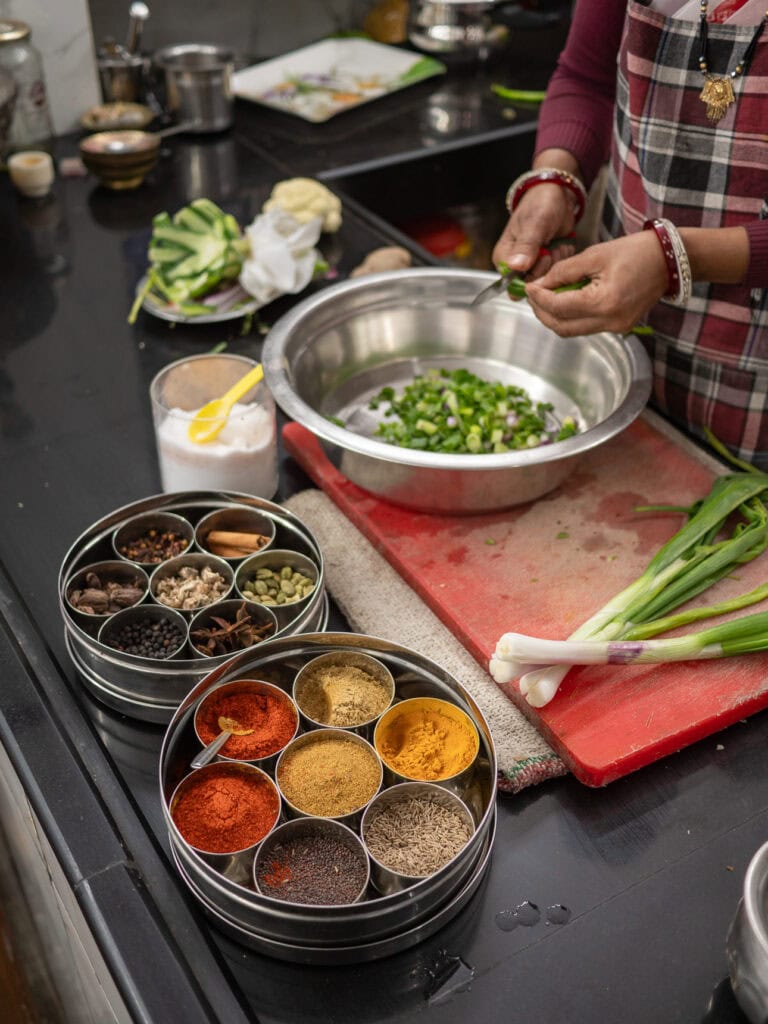 Close up of spices, chopped vegetables, and cooking tools laid out for a class in Udaipur. The colourful ingredients reflect traditional Indian cooking