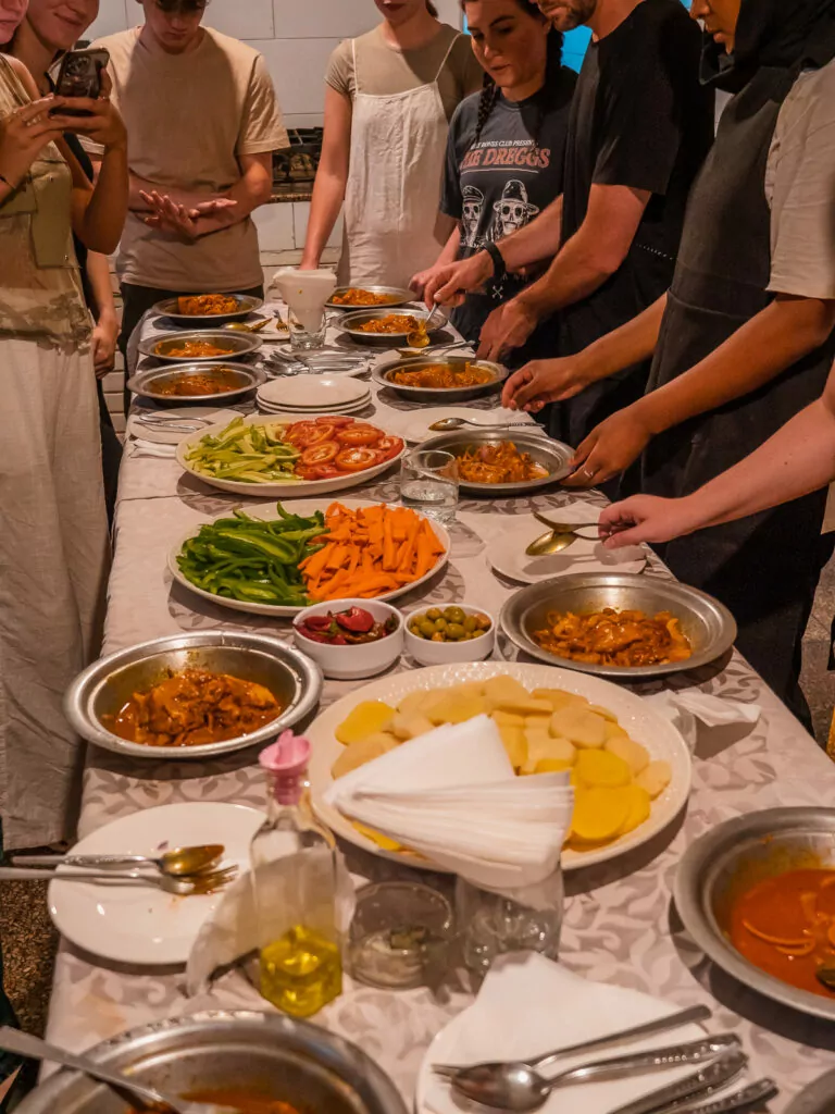 Spread of traditional Moroccan dishes and fresh ingredients on a table during a cooking class in Morocco