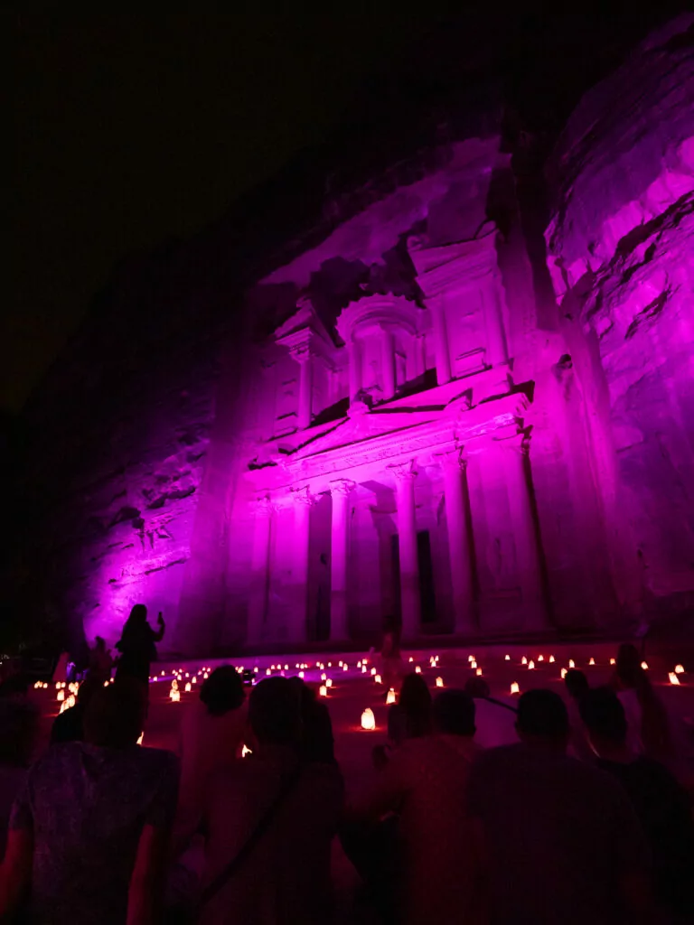 The Treasury at Petra illuminated in purple light during the Petra by Night experience in Jordan