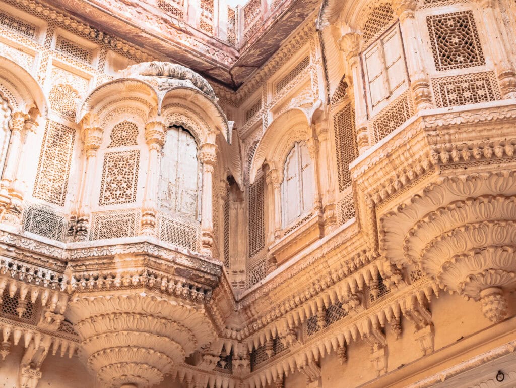 Close-up of an ornate historic building with intricate carvings and arched windows, showcasing India’s detailed architecture