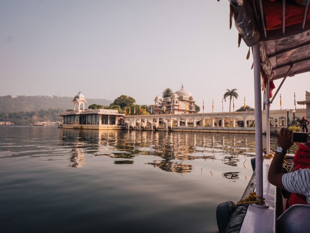 Calm lakeside view in Udaipur with historic buildings and mountains reflected in the water