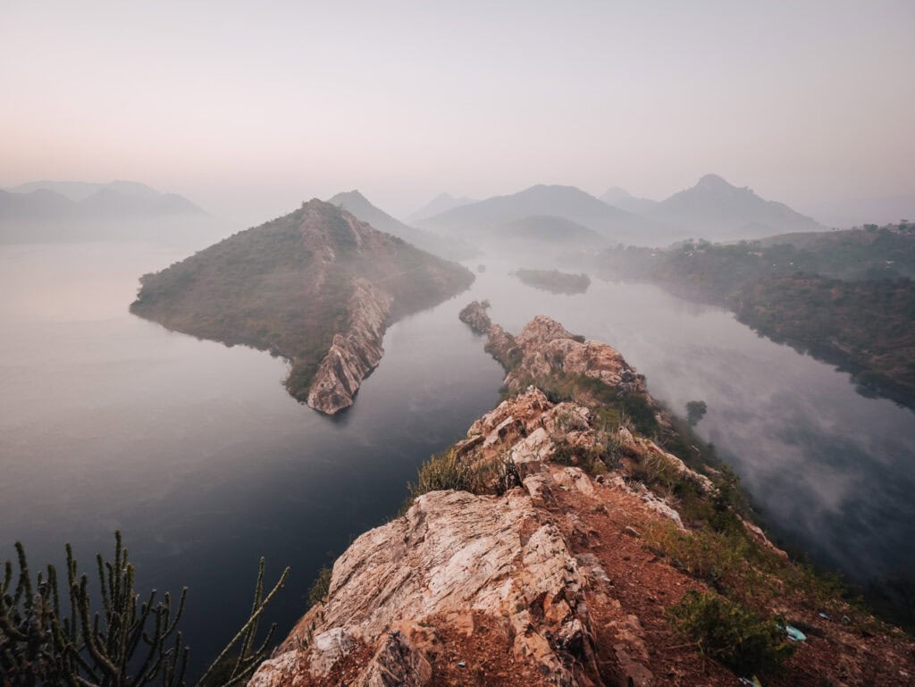 Nature trail above a lake near Premkunj Udaipur with greenery and open views of the surrounding landscape