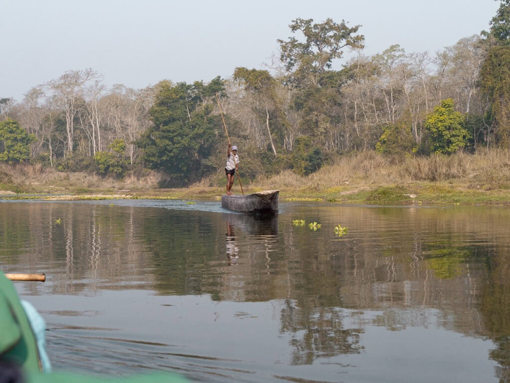 Boat on the river in Chitwan National Park with jungle along the banks