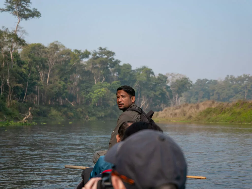 Safari guide at the front of a canoe during a river trip in Chitwan
