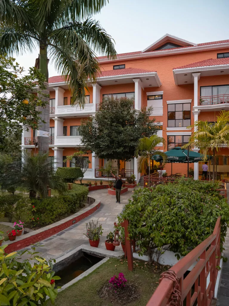 Courtyard garden at the Landmark Forest Hotel in Pokhara with palm trees and pink buildings