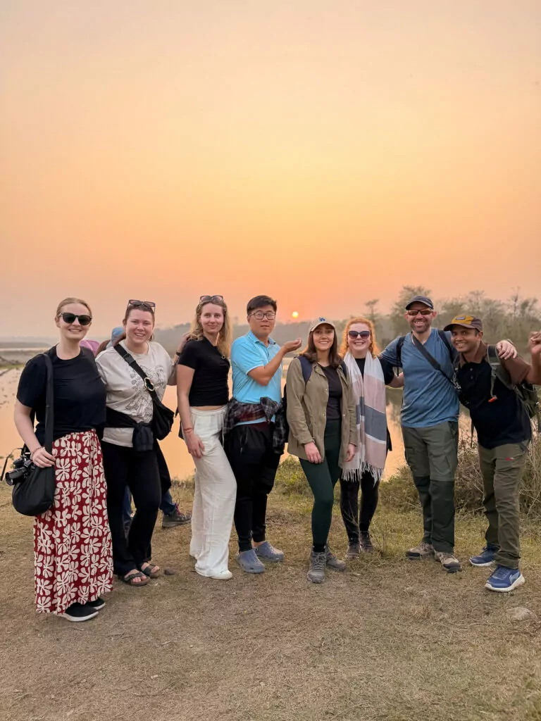 One Life Adventures Nepal Snapshot tour group posing together at sunset in Chitwan National Park