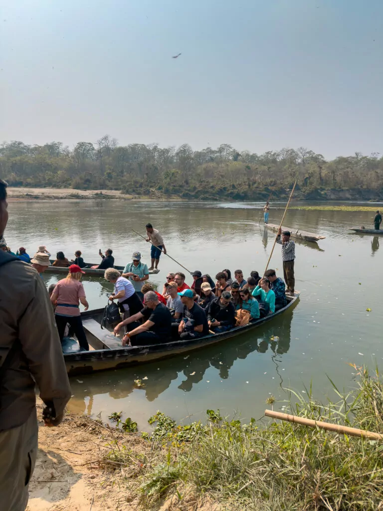 Overloaded canoe ferrying passengers across the river to the entrance of Chitwan National Park