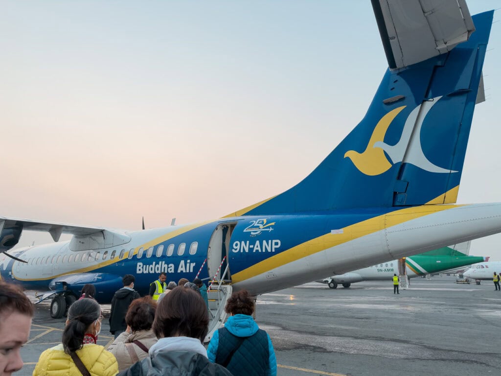 Passengers boarding a Buddha Air ATR 72 on the tarmac for a scenic Everest flight