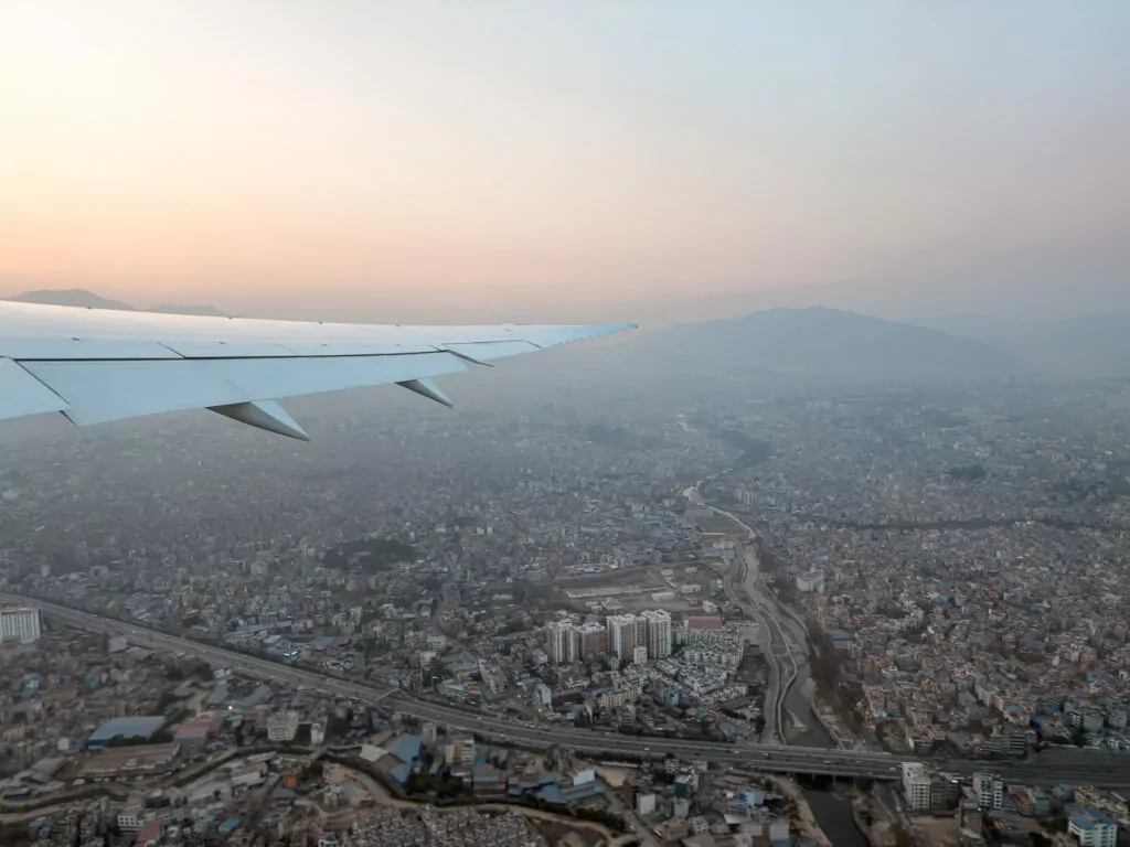 Aerial view of Kathmandu city and surrounding hills seen from a plane window