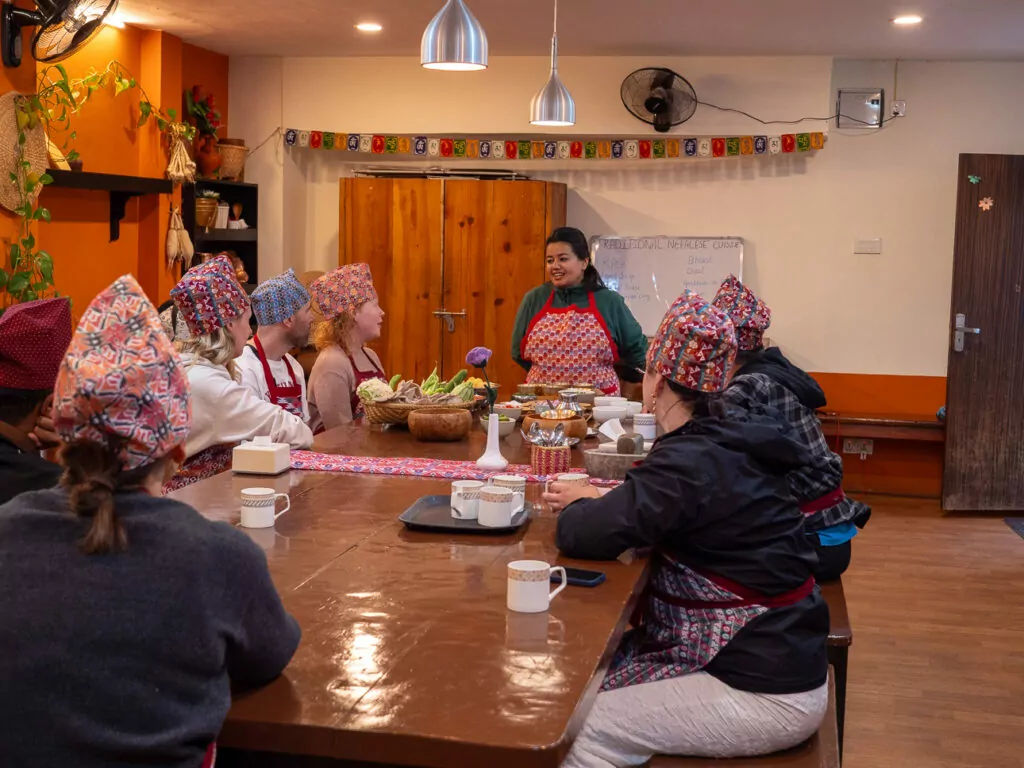 Travellers seated around a table enjoying food at the cooking class at Sungabha Seven Sisters