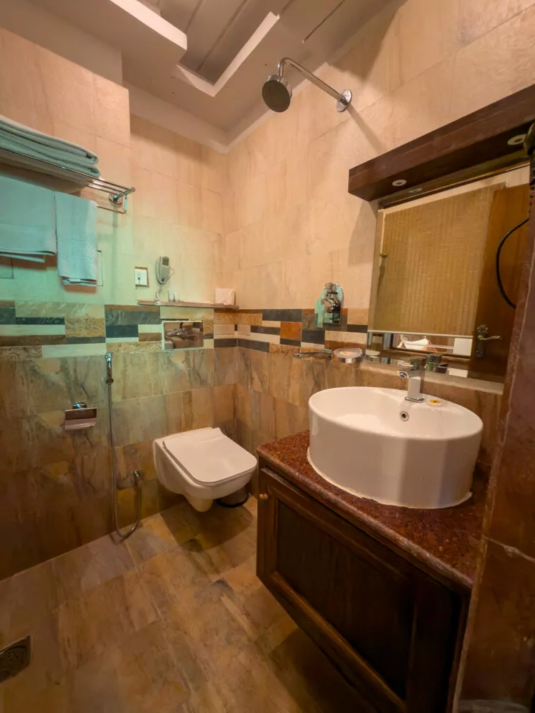 Modern bathroom with a large mirror and round basin at the Surya Heritage Hotel in Kathmandu