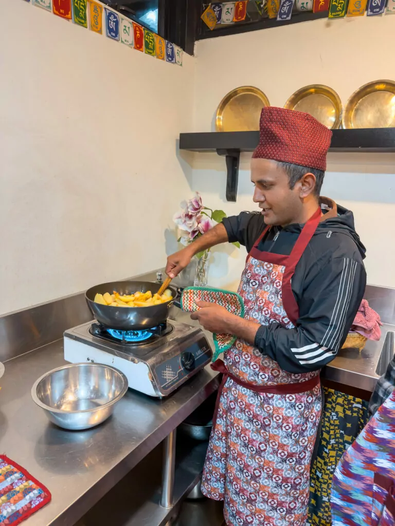 Tour guide cooking during a Nepali cooking class at Sungabha Seven Sisters in Kathmandu