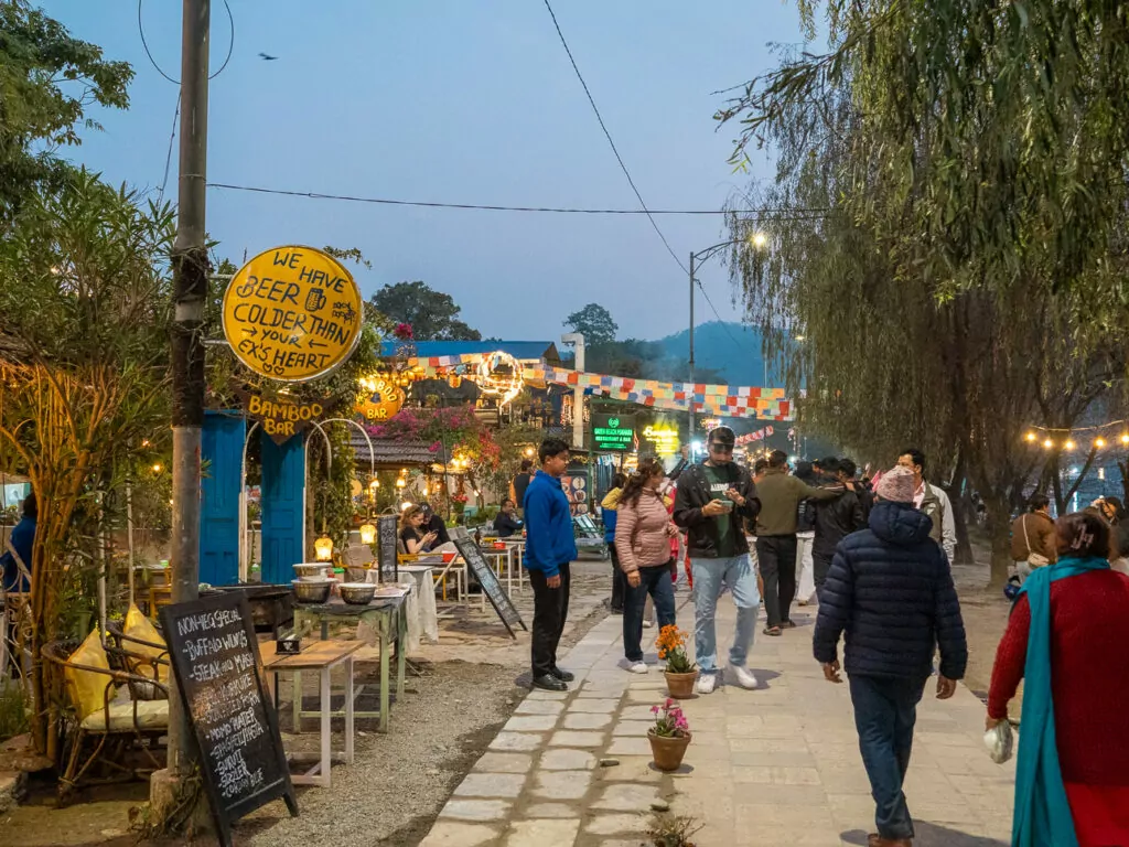 Busy Lakeside street in Pokhara at night with restaurants and shops lit up