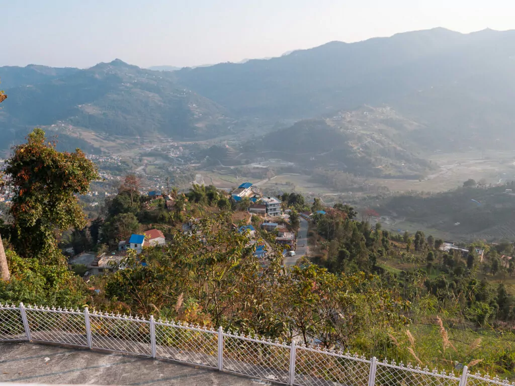 Panoramic view of green hills and hazy mountains from the Australian Camp trek