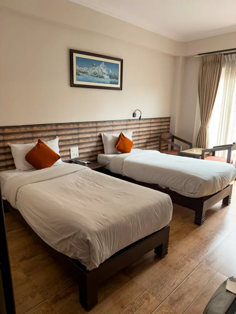 Twin beds in a clean room at Hotel Kausi in Pokhara