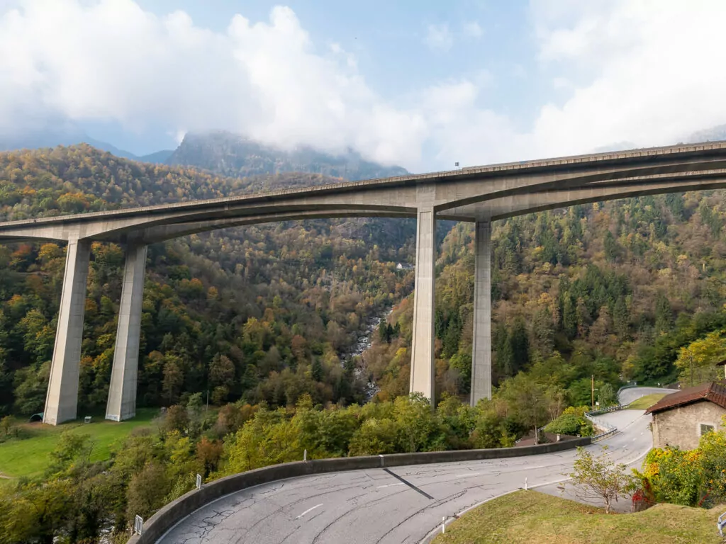 The curved Biaschina Viaduct winding through a green valley on the Gotthard Panorama Express route