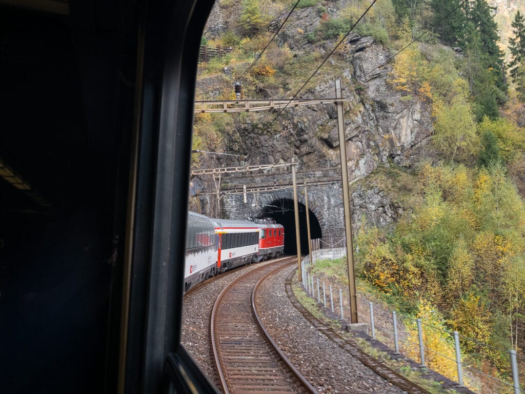 Gotthard Panorama Express train disappearing into a stone tunnel