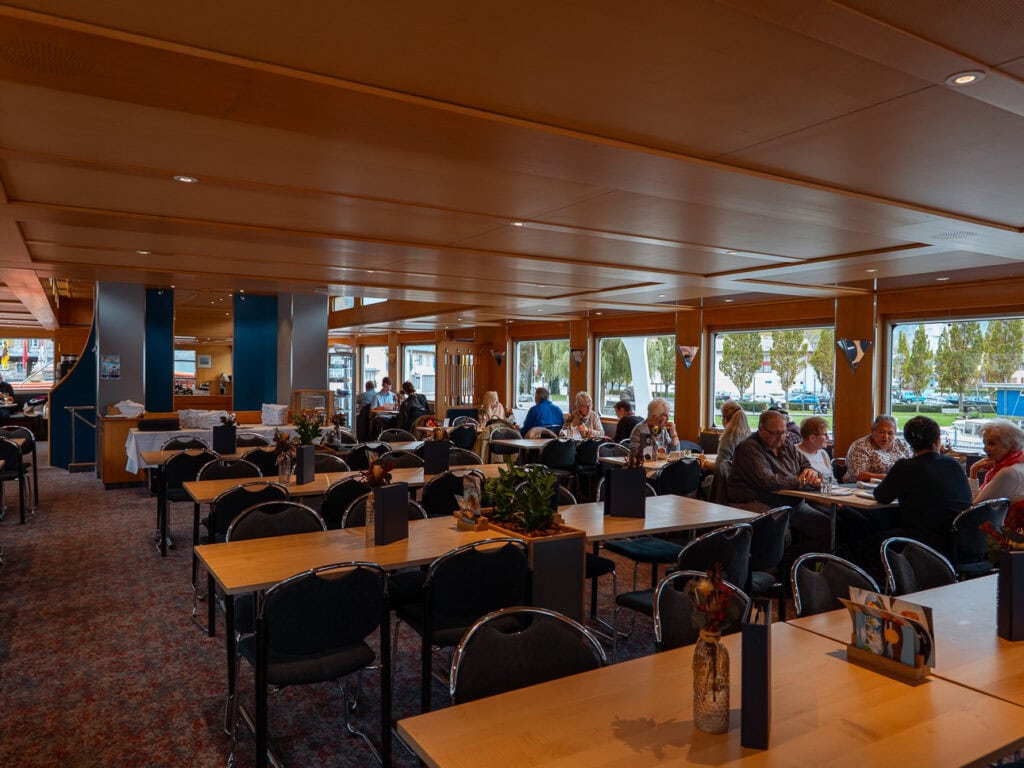 The 1st class restaurant on board a Lake Lucerne boat with wooden interiors and window seats overlooking the water