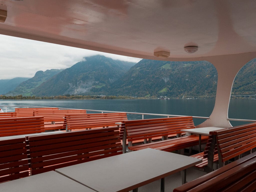 The 1st class upper deck seating area on a Lake Lucerne boat with bench seats and lake views