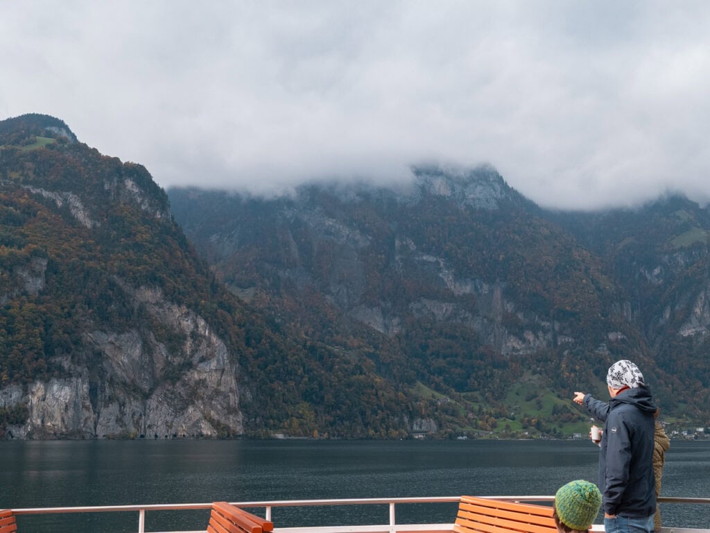 Misty mountains and a rugged cliff face rising from Lake Lucerne on an overcast autumn day