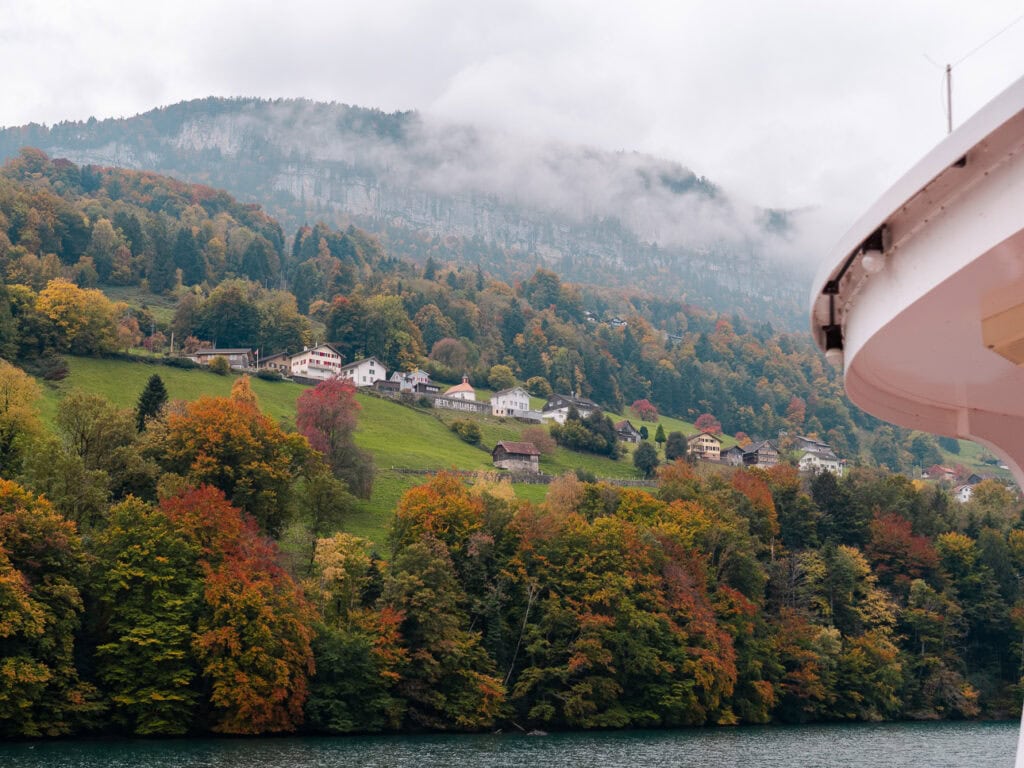 A lakeside Swiss village surrounded by autumn-coloured trees