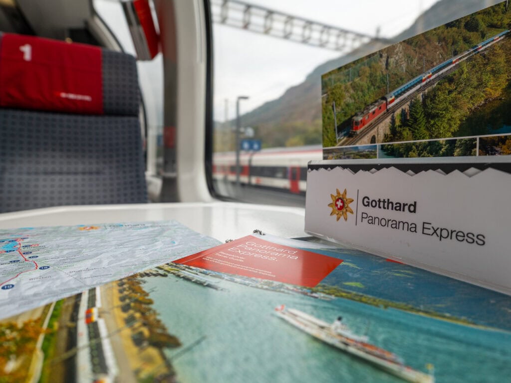 A Gotthard Panorama Express brochure on an in-seat table inside a 1st class carriage