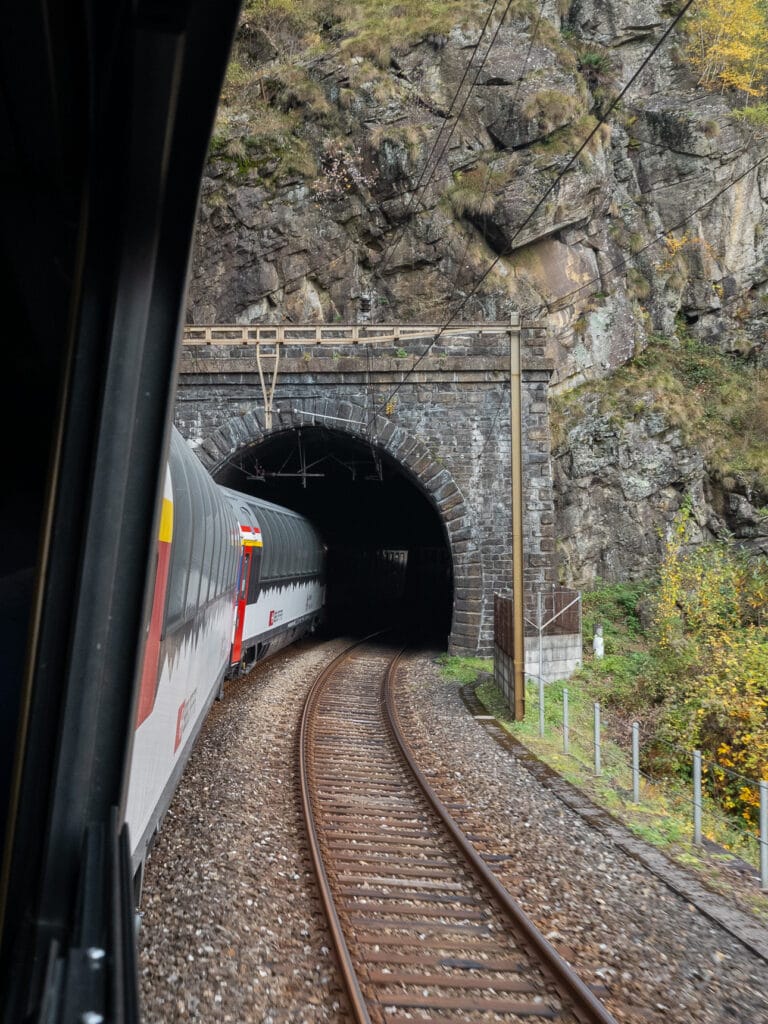 A train entering a historic tunnel on the Gotthard Panorama Express route