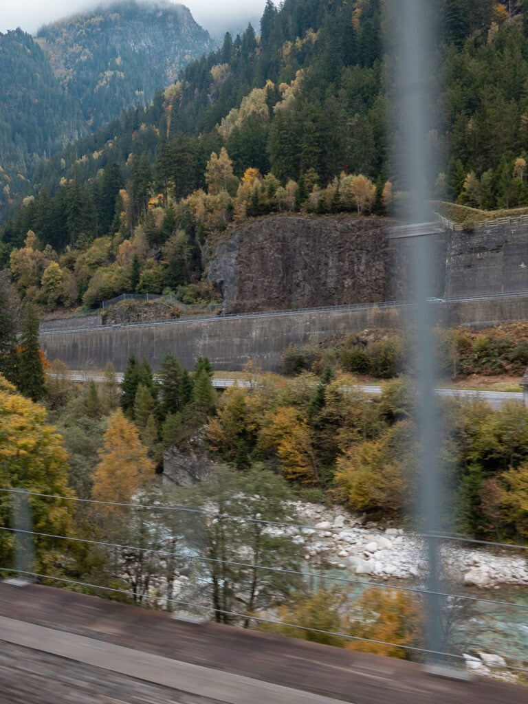 Autumn trees lining a steep valley hillside in Switzerland