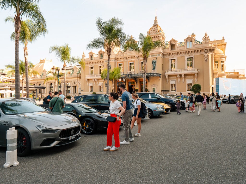 Luxury cars and tourists fill the square outside Monte Carlo Casino. The scene captures Monaco glamour on an easy French Riviera day trip