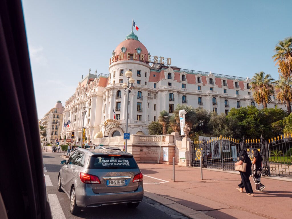 Hotel Le Negresco in Nice seen from a taxi on the road. The sign reads "Le Negresco"