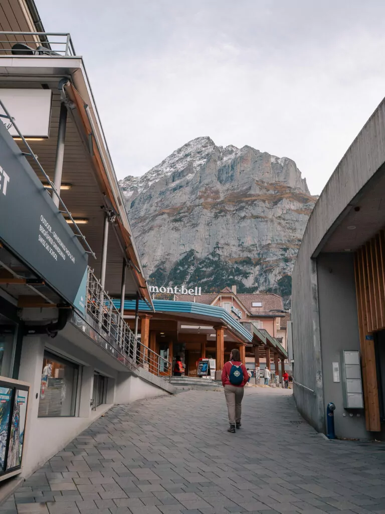 Traveller walking through Grindelwald village towards the mountains