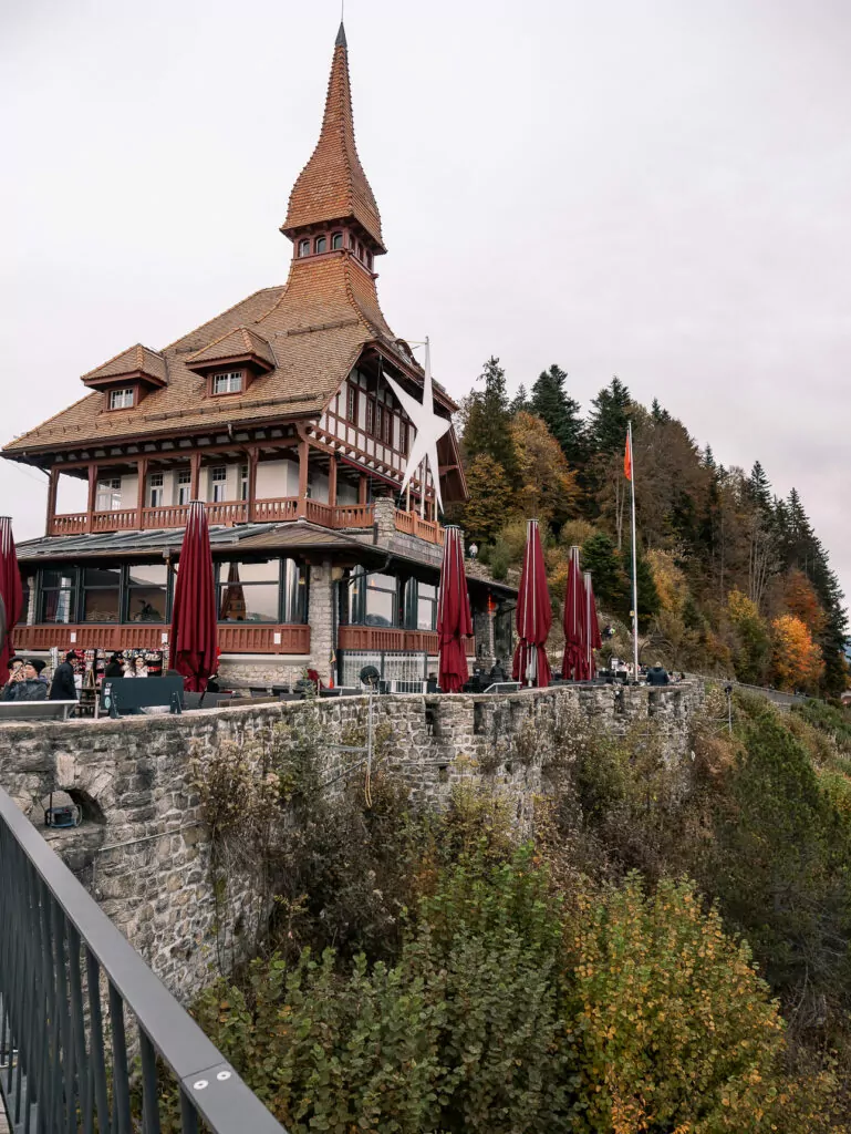 Harder Kulm viewpoint building above Interlaken with autumn forest behind it