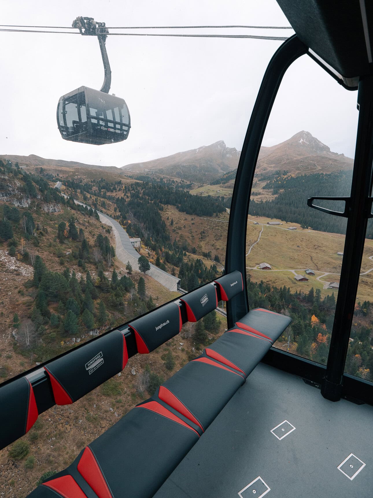 View from inside a cable car towards another gondola and mountain scenery near Jungfraujoch. This cable car gets a 25% discount with the Berner Oberland Pass.