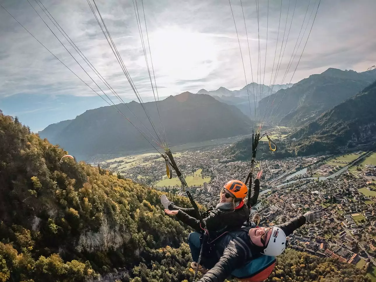 Tandem paragliding above Interlaken with Lake Thun and the Swiss Alps below