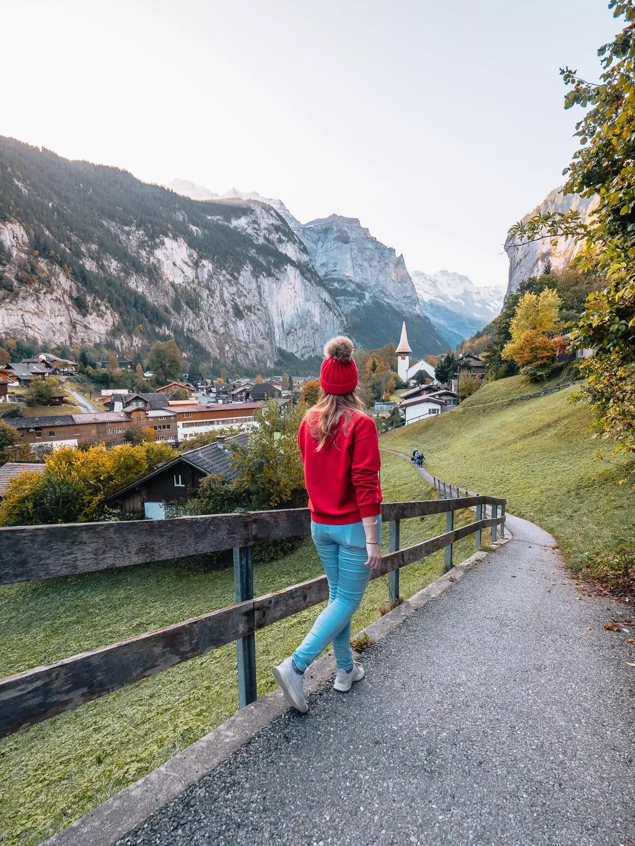 Traveller walking through Lauterbrunnen with mountain and village views