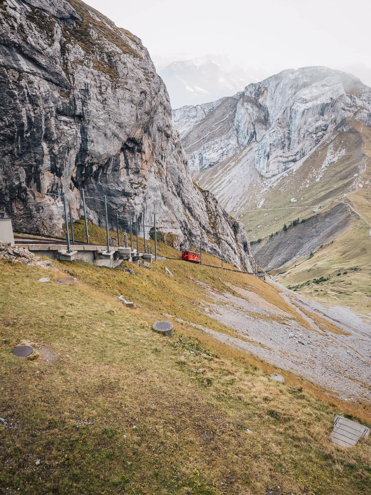 Red mountain train travelling through rocky scenery near Mount Pilatus