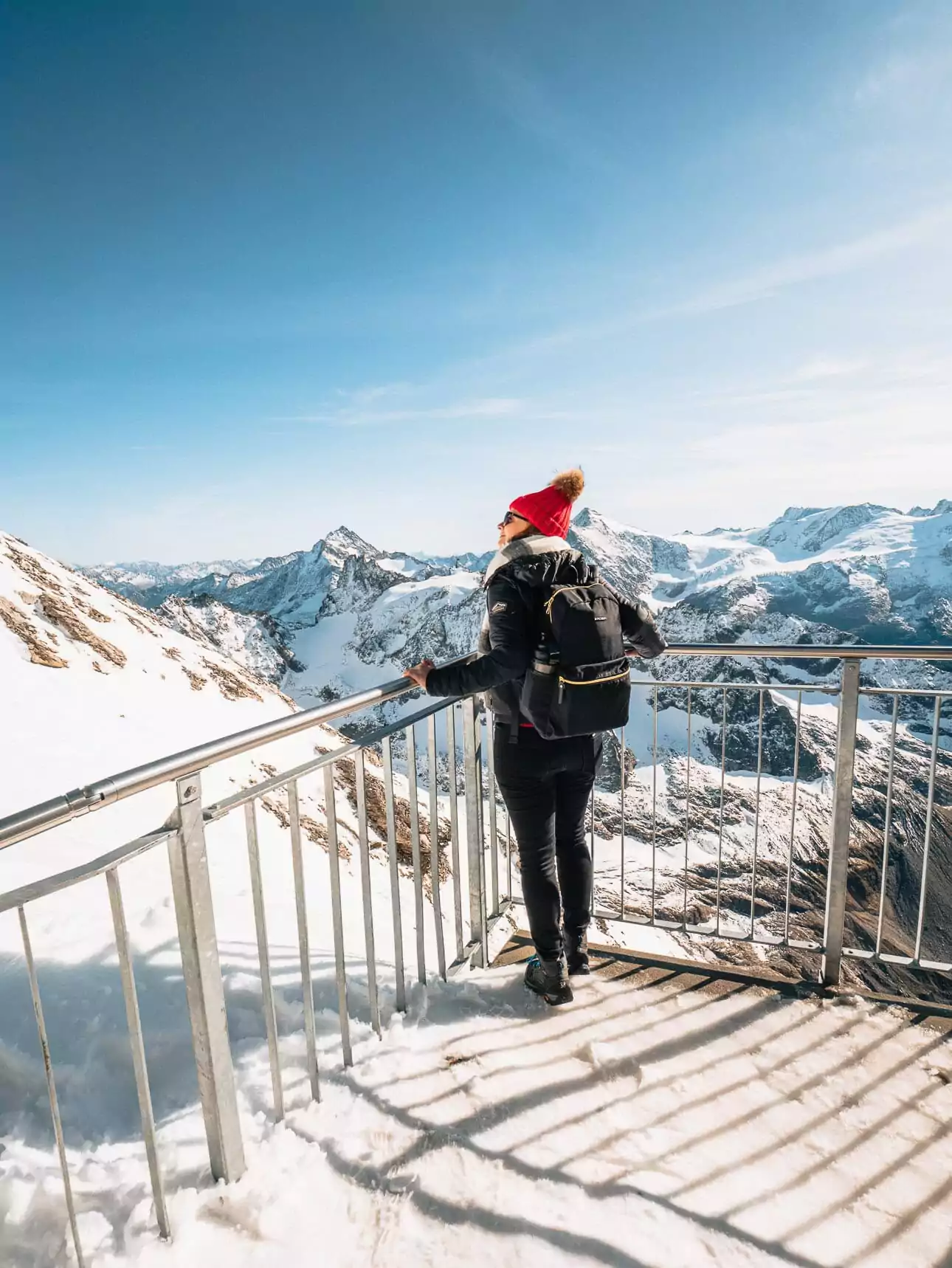 Traveller looking out over snowy mountains from Mount Titlis in Switzerland