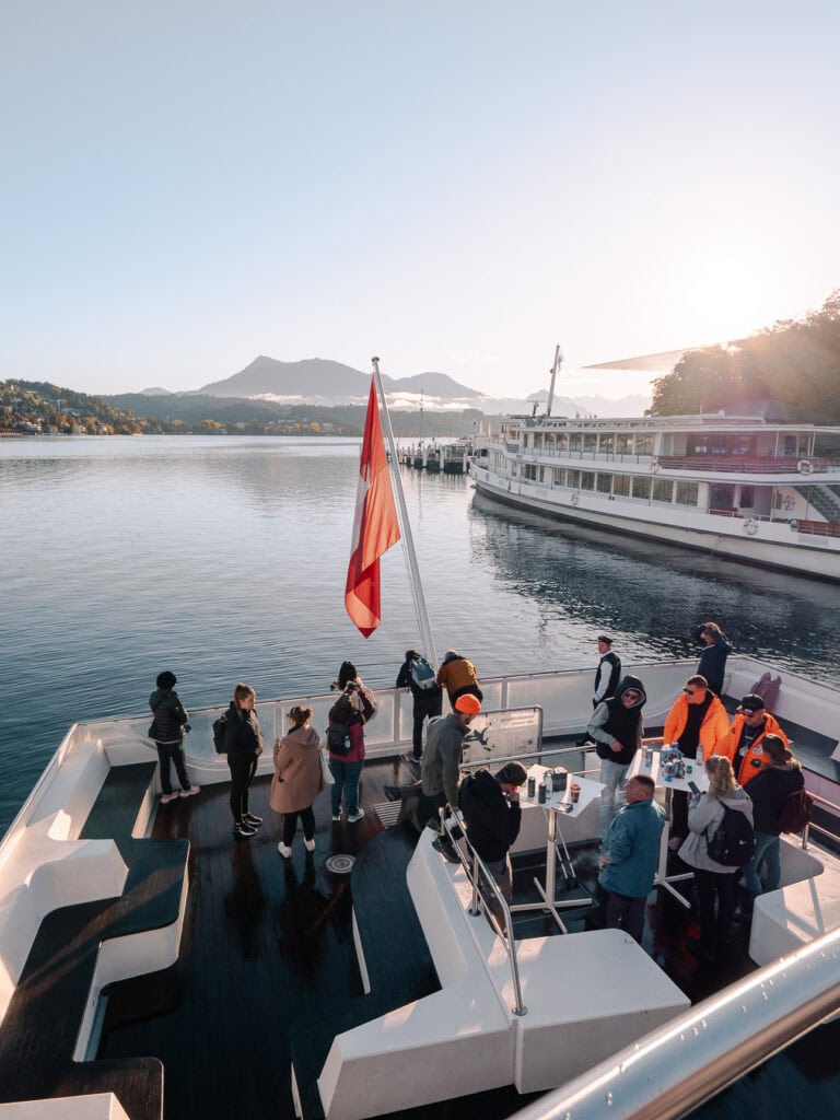 Lake Lucerne cruise boat with passengers on deck and mountains in the distance