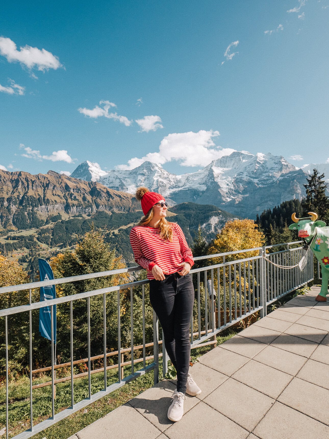 Traveller at a mountain viewpoint in Mürren with the Eiger, Mönch and Jungfrau behind her